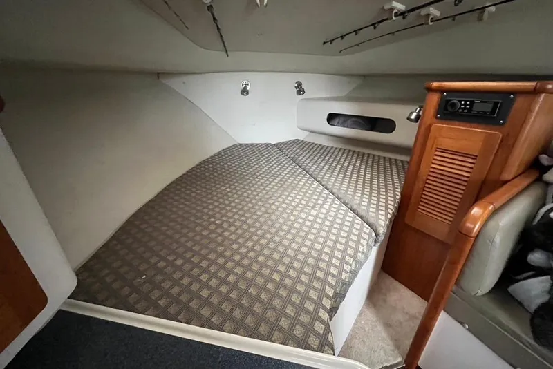 Slide: The Image of Interior cabin of 2005 Pursuit 3100 Offshore boat with bed and wooden storage. - 40