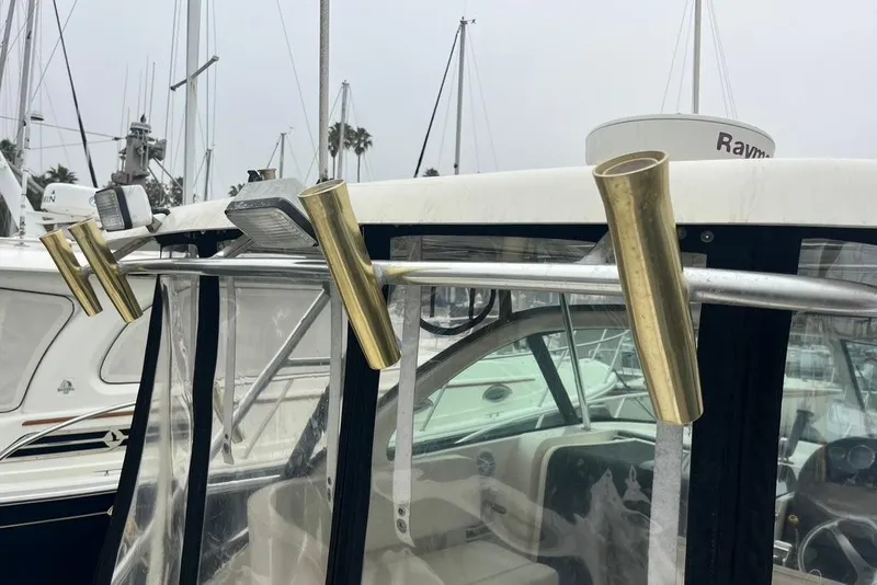 Slide: The Image of 2005 Pursuit 3100 Offshore boat with brass rod holders and clear enclosure. - 43