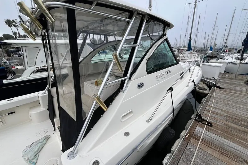 Slide: The Image of 2005 Pursuit 3100 Offshore boat docked at marina, featuring sleek design and fishing rod holders. - 5
