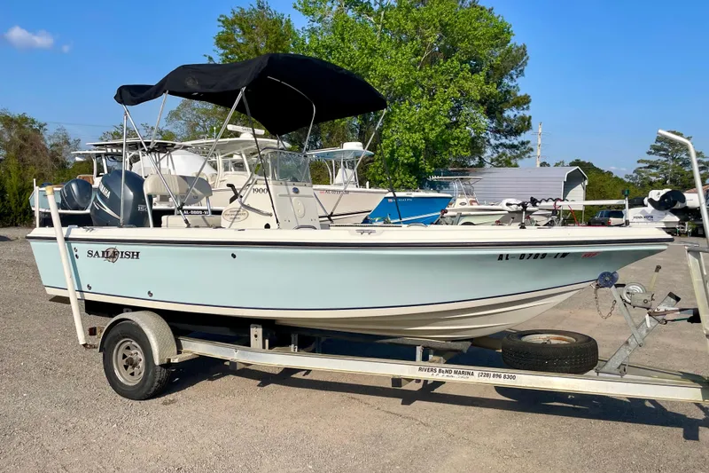 The Image of 2005 Sailfish 1900 BB Bay Boat on trailer, parked outdoors under clear sky. - 0