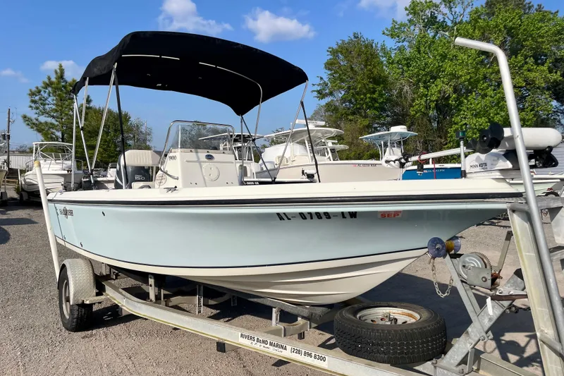 Slide: The Image of 2005 Sailfish 1900 BB Bay Boat on trailer, featuring a canopy and outboard motor. - 1