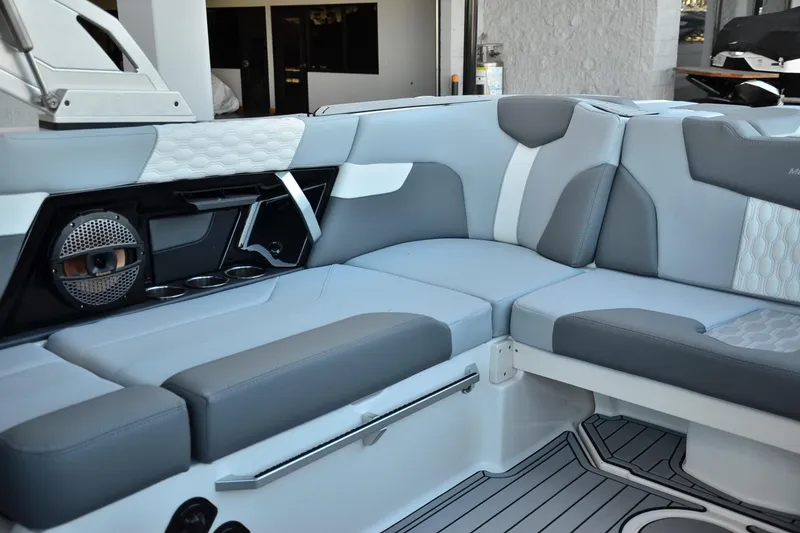 Slide: The Image of 2024 MasterCraft XT22 T boat interior with gray seating and speaker system. - 18