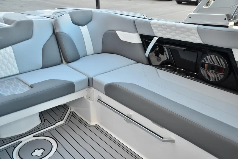 Slide: The Image of 2024 MasterCraft XT22 T boat interior with gray seating and modern audio system. - 19