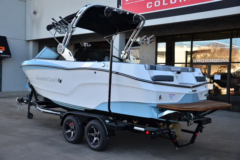 Slide: The Image of 2024 MasterCraft XT22 T boat on trailer outside showroom. - 3
