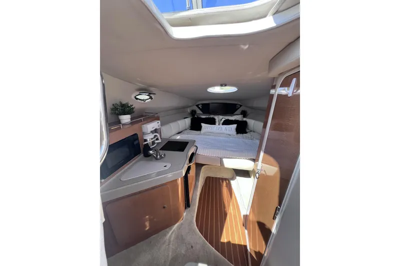 Slide: The Image of Interior of 2008 Larson Cabrio 260 boat with cozy bed and kitchenette. - 11