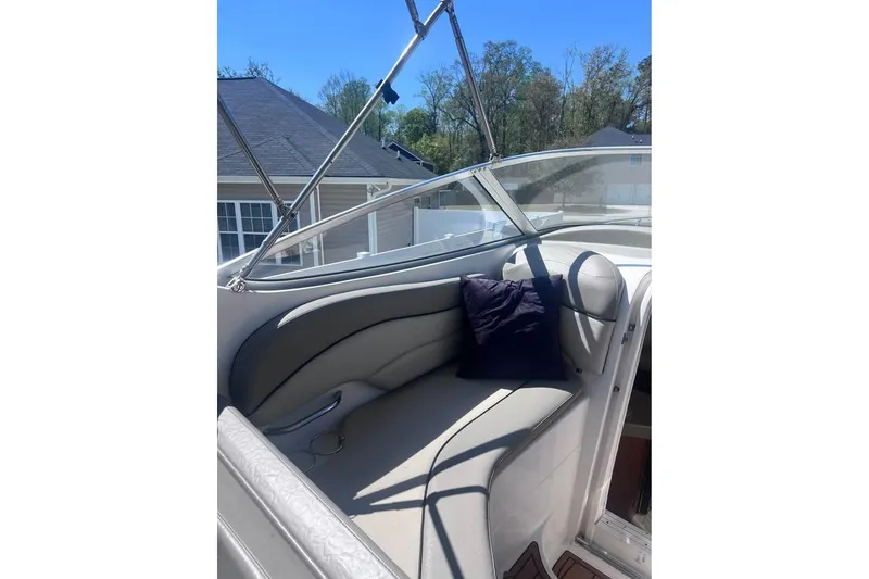 Slide: The Image of 2008 Larson Cabrio 260 boat interior with cushioned seating and a pillow. - 15