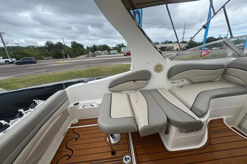 Slide: The Image of 2008 Larson Cabrio 260 boat interior with cushioned seating and wood-style flooring. - 17