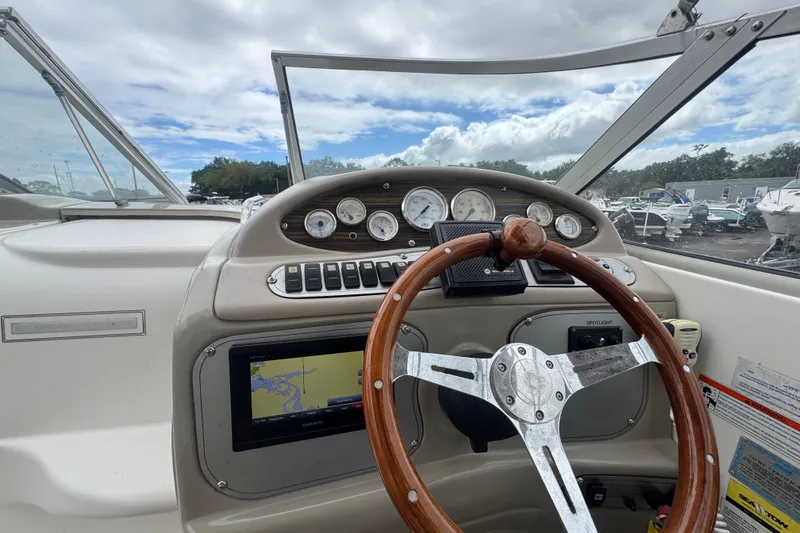 Slide: The Image of 2008 Larson Cabrio 260 boat dashboard with wooden steering wheel and navigation system. - 22