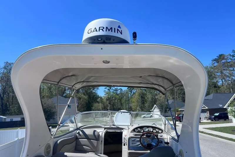 Slide: The Image of 2008 Larson Cabrio 260 boat with Garmin radar, parked in a residential area. - 3