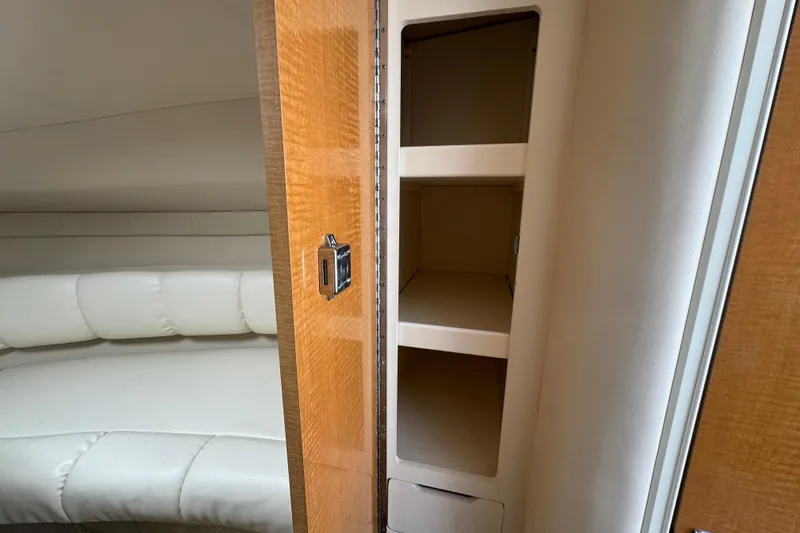 Slide: The Image of Interior of 2008 Larson Cabrio 260 showing storage shelves and cushioned seating area. - 32