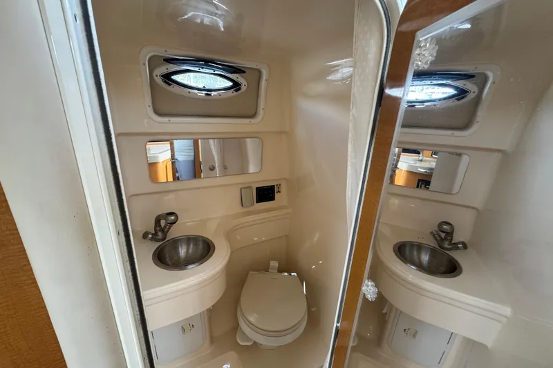 Slide: The Image of 2008 Larson Cabrio 260 boat bathroom with sink, toilet, and mirror. - 33