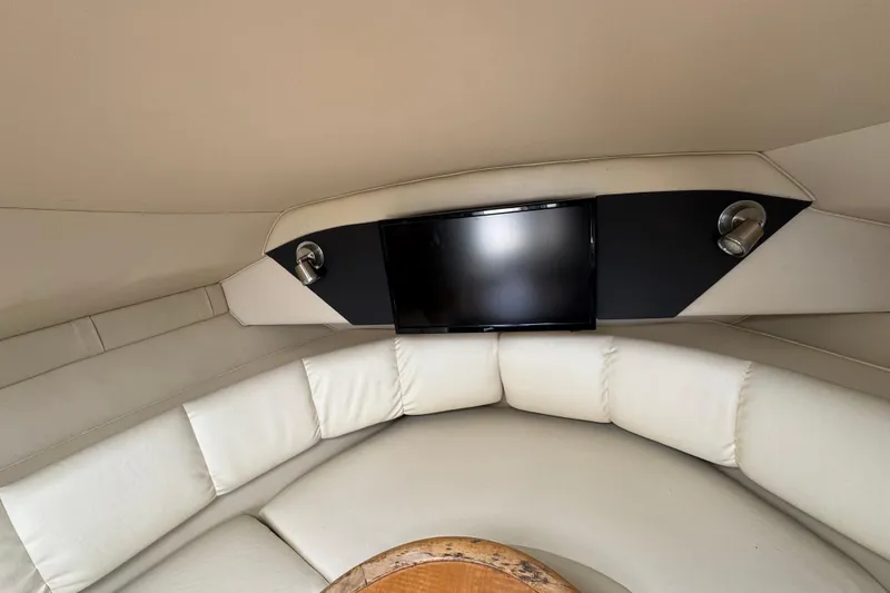 Slide: The Image of Interior of 2008 Larson Cabrio 260 boat with TV and white seating. - 35