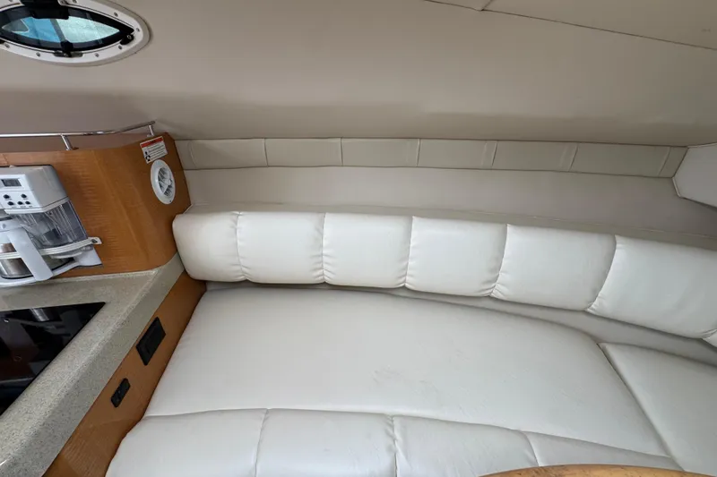 Slide: The Image of 2008 Larson Cabrio 260 interior with white leather seating and kitchenette area. - 36