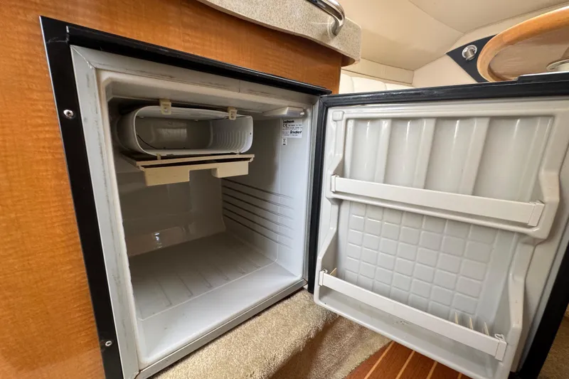 Slide: The Image of Open refrigerator inside a 2008 Larson Cabrio 260 boat cabin. - 38