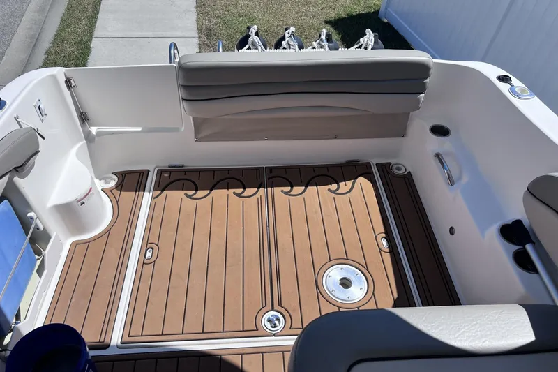 Slide: The Image of 2008 Larson Cabrio 260 boat interior with teak flooring and cushioned seating. - 4