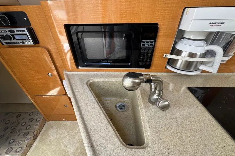 Slide: The Image of 2008 Larson Cabrio 260 boat kitchen with sink, microwave, and coffee maker. - 42