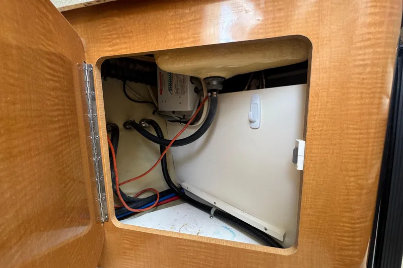 Slide: The Image of Open cabinet in 2008 Larson Cabrio 260 boat showing wiring and components. - 43