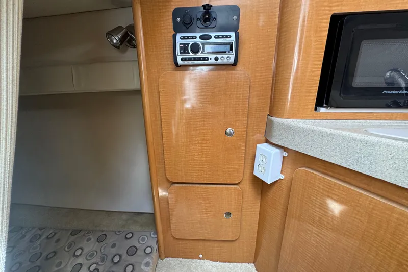 Slide: The Image of Interior of a 2008 Larson Cabrio 260 boat featuring wood cabinetry and a control panel. - 44