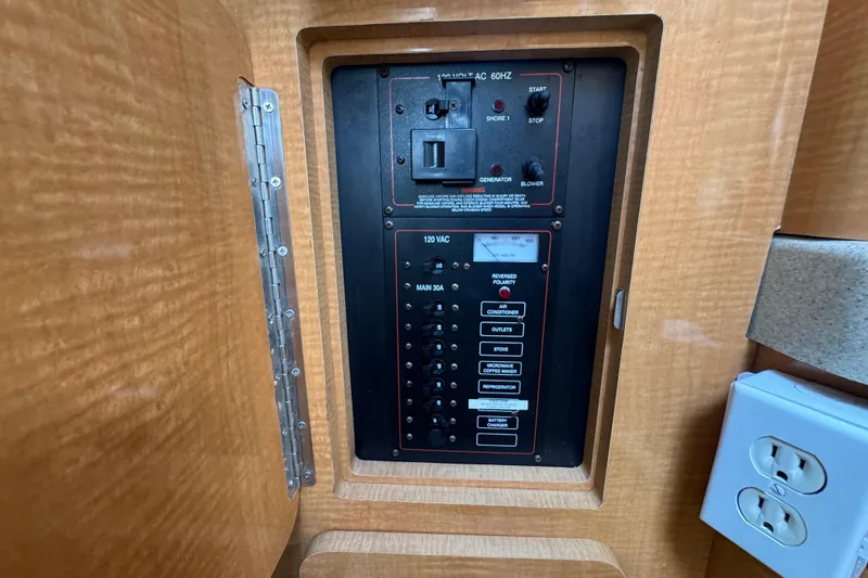 Slide: The Image of Electrical panel inside a 2008 Larson Cabrio 260 boat, featuring various switches and outlets. - 46