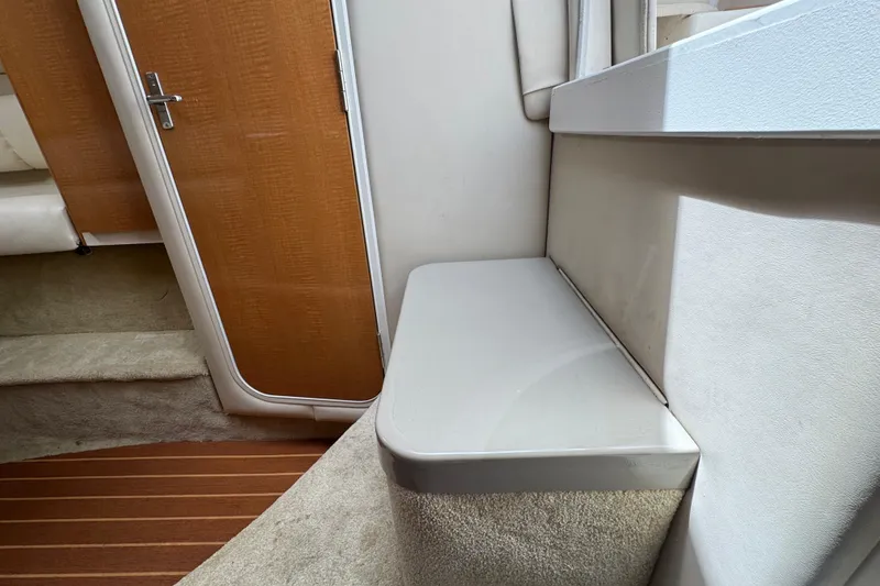 Slide: The Image of Interior of 2008 Larson Cabrio 260 boat, featuring wooden door and carpeted steps. - 49