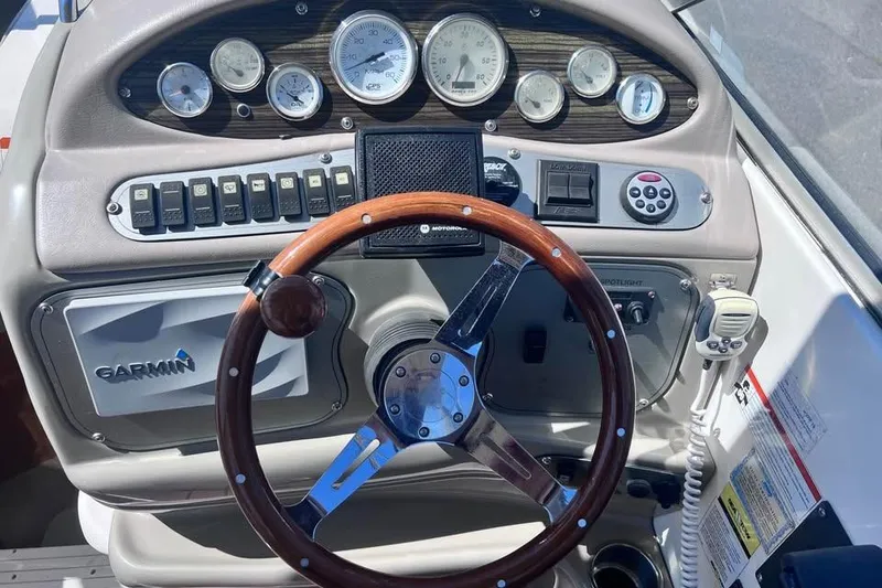 Slide: The Image of 2008 Larson Cabrio 260 dashboard with Garmin GPS, gauges, and wood-accented steering wheel. - 5
