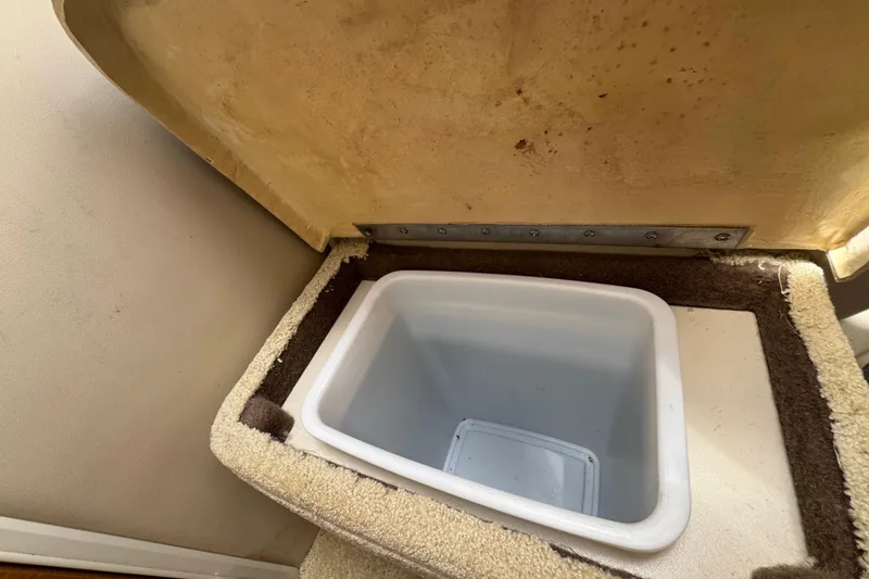 Slide: The Image of Storage compartment in 2008 Larson Cabrio 260 boat, featuring an open lid and interior container. - 50