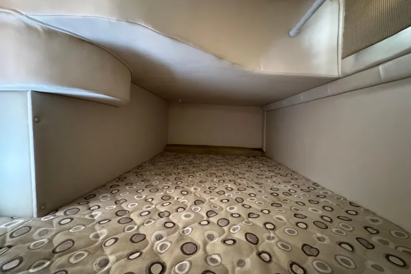 Slide: The Image of Interior cabin of 2008 Larson Cabrio 260 boat with patterned bedding. - 51