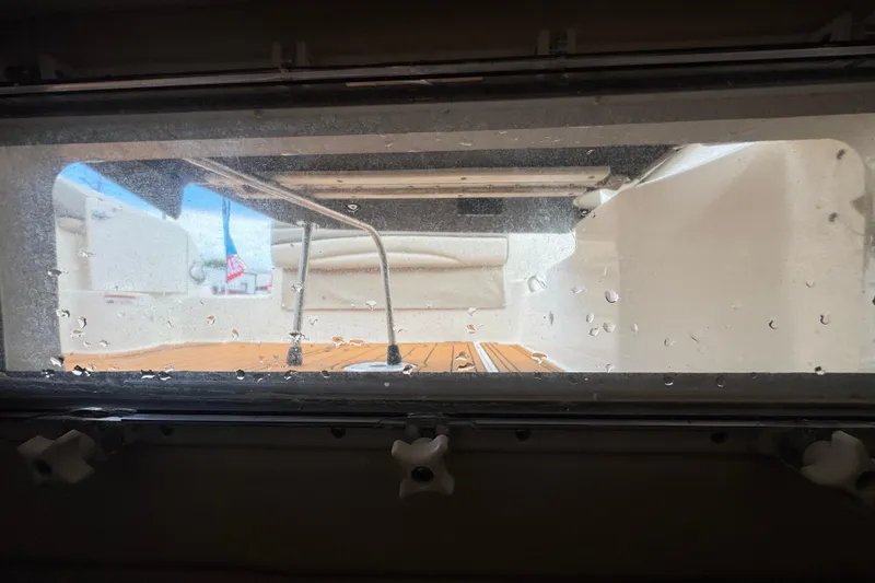 Slide: The Image of View through a window on a 2008 Larson Cabrio 260 boat, showing deck and seating. - 53