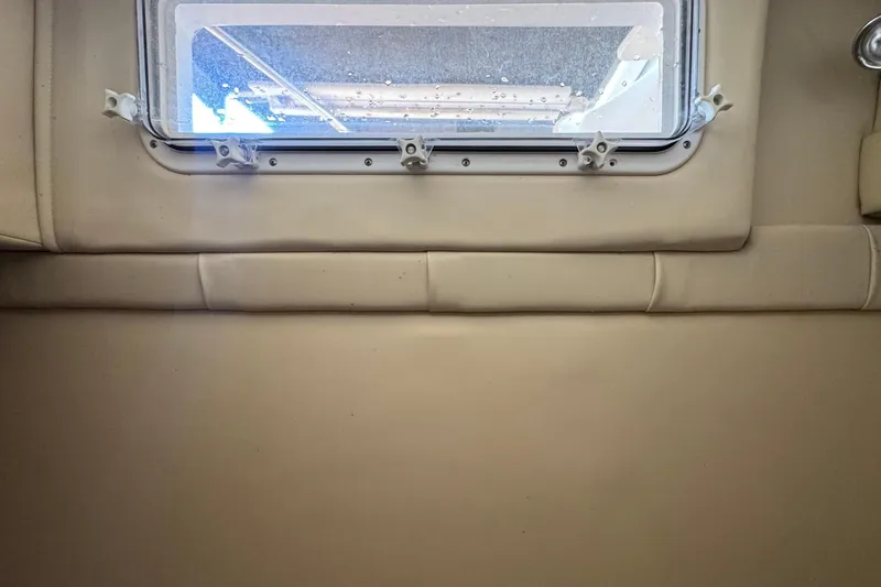 Slide: The Image of Interior cabin view of a 2008 Larson Cabrio 260 boat with a window. - 54