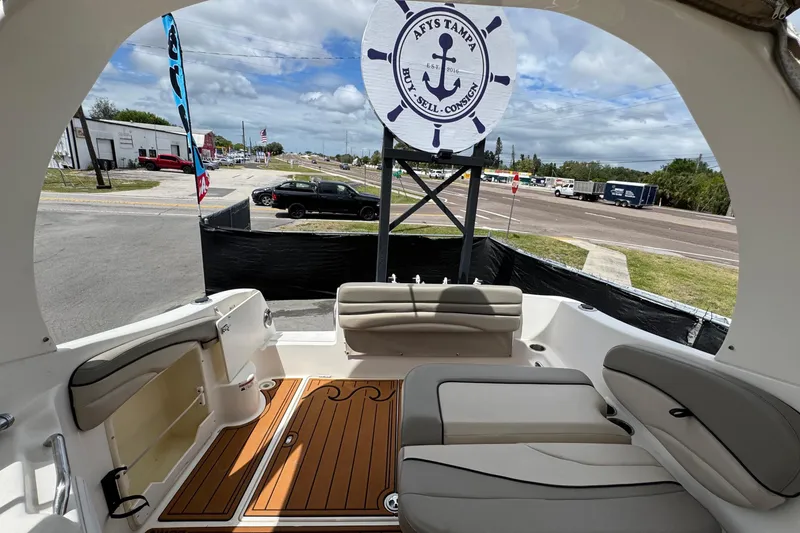 Slide: The Image of 2008 Larson Cabrio 260 boat interior with seating, wood flooring, and outdoor view. - 60