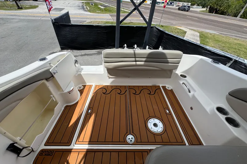 Slide: The Image of 2008 Larson Cabrio 260 boat interior with teak flooring and cushioned seating. - 61