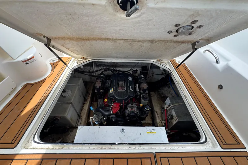 Slide: The Image of Open engine compartment of a 2008 Larson Cabrio 260 boat, showcasing the engine and components. - 62