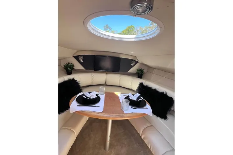 Slide: The Image of Interior of 2008 Larson Cabrio 260 boat with elegant dining setup and plush seating. - 9