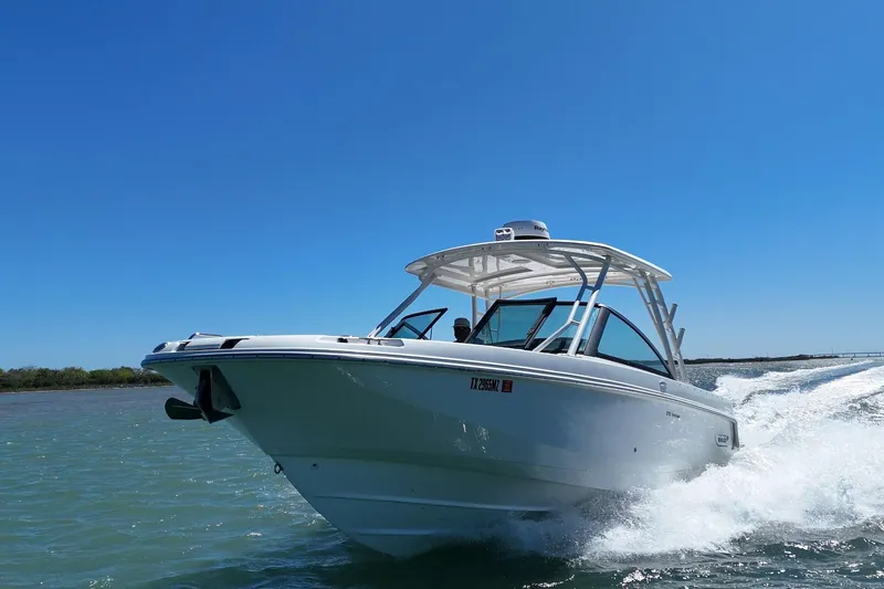 The Image of 2017 Boston Whaler 270 Vantage cruising on open water under clear blue sky. - 0