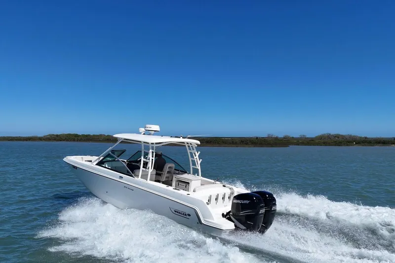 Slide: The Image of 2017 Boston Whaler 270 Vantage cruising on open water under clear blue skies. - 11