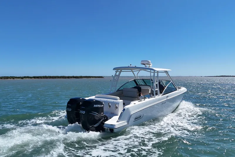 Slide: The Image of 2017 Boston Whaler 270 Vantage cruising on open water under clear blue skies. - 14