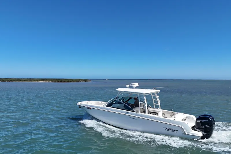 Slide: The Image of 2017 Boston Whaler 270 Vantage cruising on open water under clear blue skies. - 15