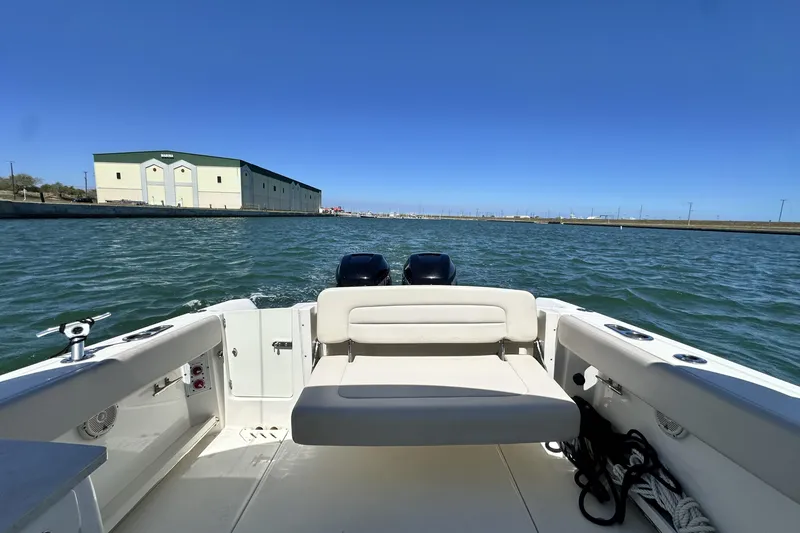 Slide: The Image of 2017 Boston Whaler 270 Vantage boat on water, with marina building in background. - 19