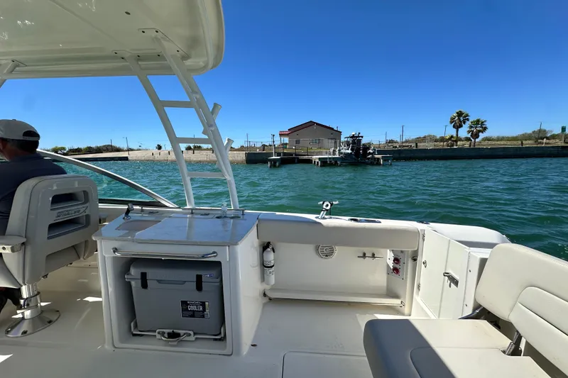Slide: The Image of 2017 Boston Whaler 270 Vantage on water, featuring spacious seating and storage, under clear blue sky. - 22