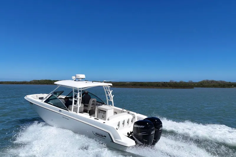 Slide: The Image of 2017 Boston Whaler 270 Vantage cruising on open water under clear blue skies. - 3