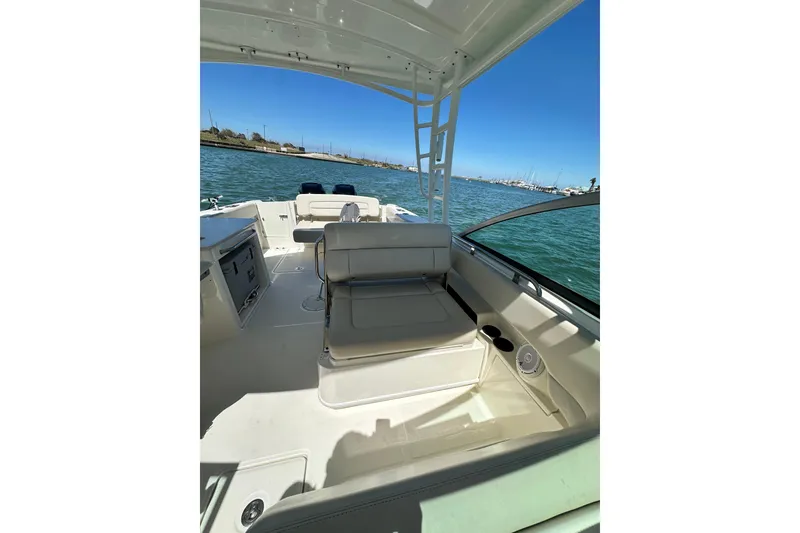 Slide: The Image of 2017 Boston Whaler 270 Vantage boat interior with seating, on calm water. - 32