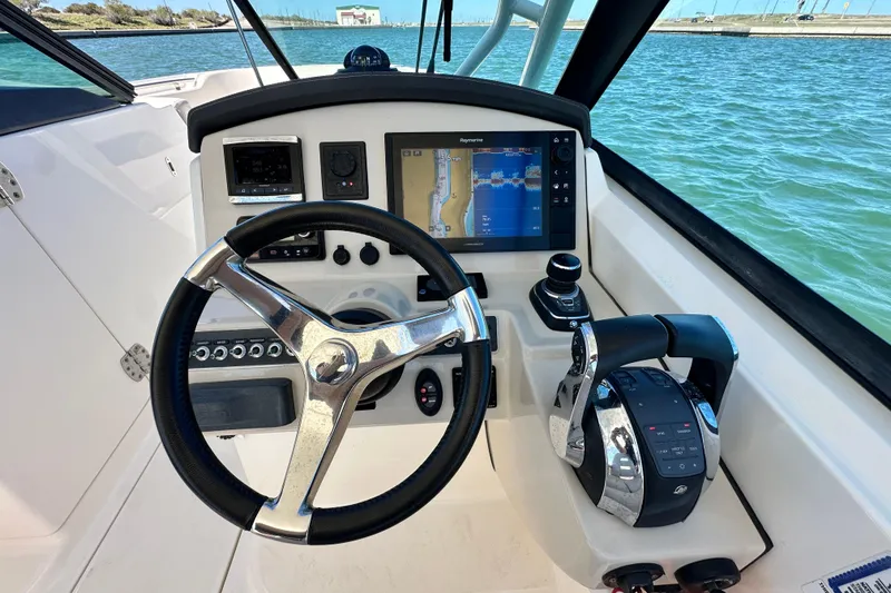 Slide: The Image of 2017 Boston Whaler 270 Vantage boat dashboard with steering wheel and navigation system. - 37