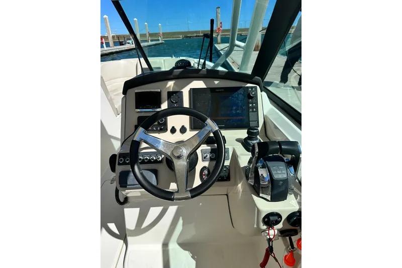 Slide: The Image of 2017 Boston Whaler 270 Vantage helm with steering wheel and navigation controls. - 40