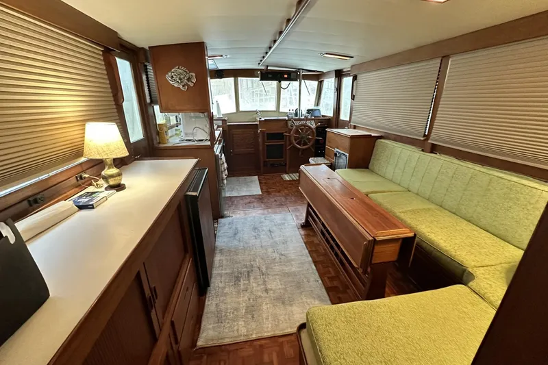 Slide: The Image of Interior of a 1979 Grand Banks 42 Classic yacht with wood finishes and green seating. - 18