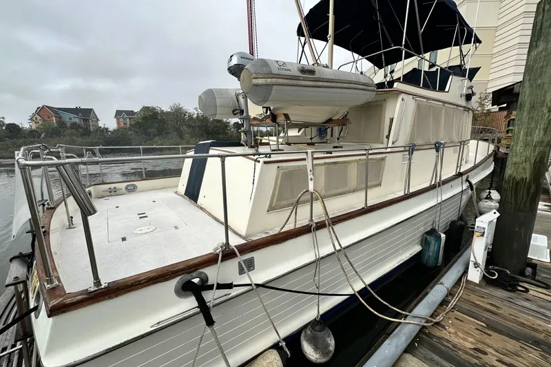 Slide: The Image of 1979 Grand Banks 42 Classic yacht docked, featuring spacious deck and lifeboat. - 2