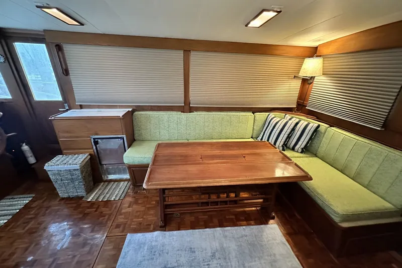 Slide: The Image of Interior of a 1979 Grand Banks 42 Classic yacht with green seating and wooden table. - 20