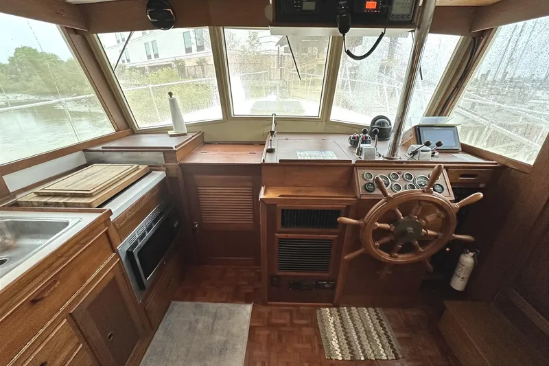 Slide: The Image of 1979 Grand Banks 42 Classic boat interior with wooden helm and kitchen area. - 23
