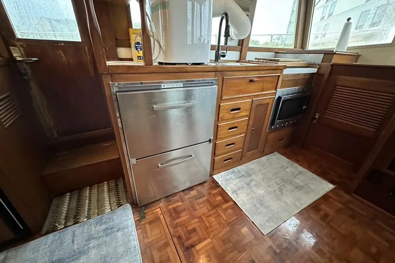 Slide: The Image of Interior of 1979 Grand Banks 42 Classic yacht kitchen with wooden cabinetry and stainless steel appliances. - 29