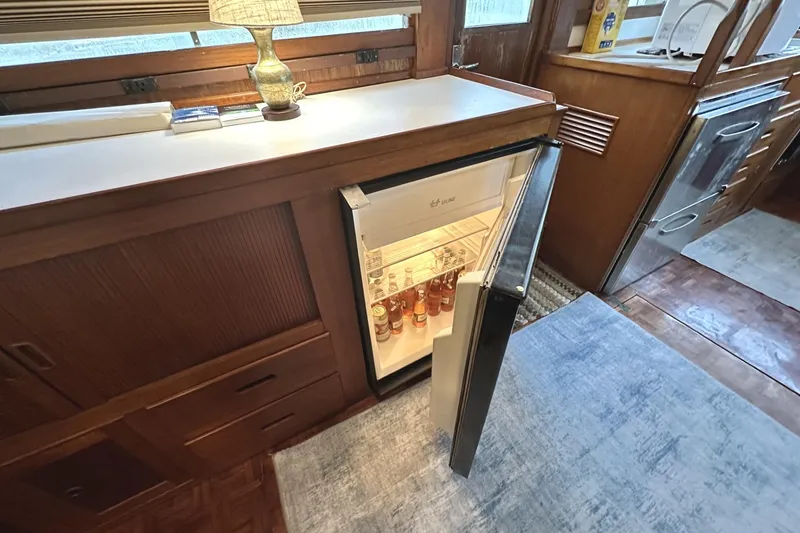 Slide: The Image of 1979 Grand Banks 42 Classic interior with open fridge and wooden cabinetry. - 32