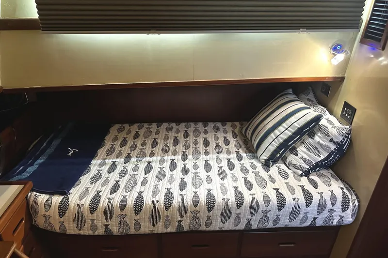 Slide: The Image of Cozy cabin bed in a 1979 Grand Banks 42 Classic yacht, featuring nautical-themed bedding. - 36